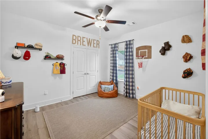 This naturally illuminated bedroom offers LVP flooring and a ceiling fan for comfort.