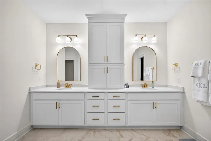 Dual vanity with elegant arched mirrors creates a harmonious primary bath retreat.