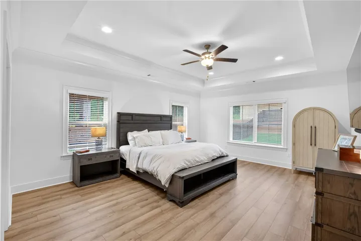Relax in a generously proportioned sleeping sanctuary with elegant tray ceilings and rich LVP flooring.