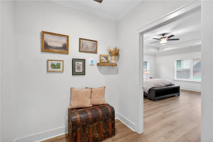 LVP floors stretch into a well-lit bedroom, offering ample space and bright window views.
