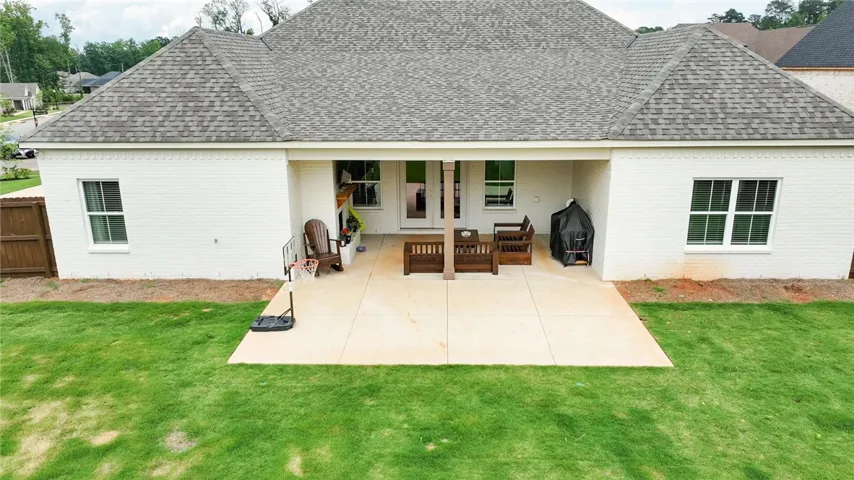 A spacious, paved patio extends from the back of the home, offering ample room for outdoor enjoyment.