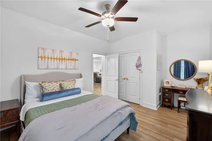 Comfortable bedroom features high ceilings and LVP flooring, providing a calm retreat.