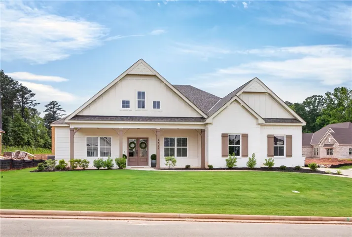 A graceful facade features an inviting covered porch and neat landscaping.