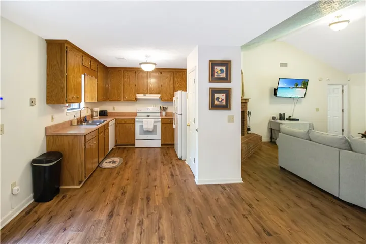 A classic kitchen with durable wood flooring seamlessly flows into the living area, perfect for daily living.