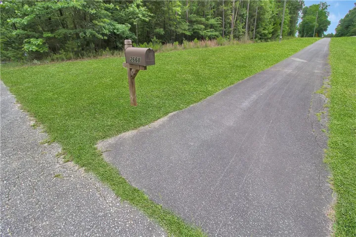 A long, inviting driveway leads to this wooded retreat, offering peace and privacy. Sidewalks from the driveway for biking/jogging