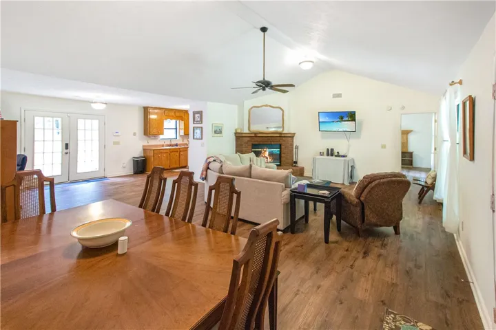 A welcoming great room, featuring a cozy brick fireplace and rich wood flooring, seamlessly connects to a classic kitchen.