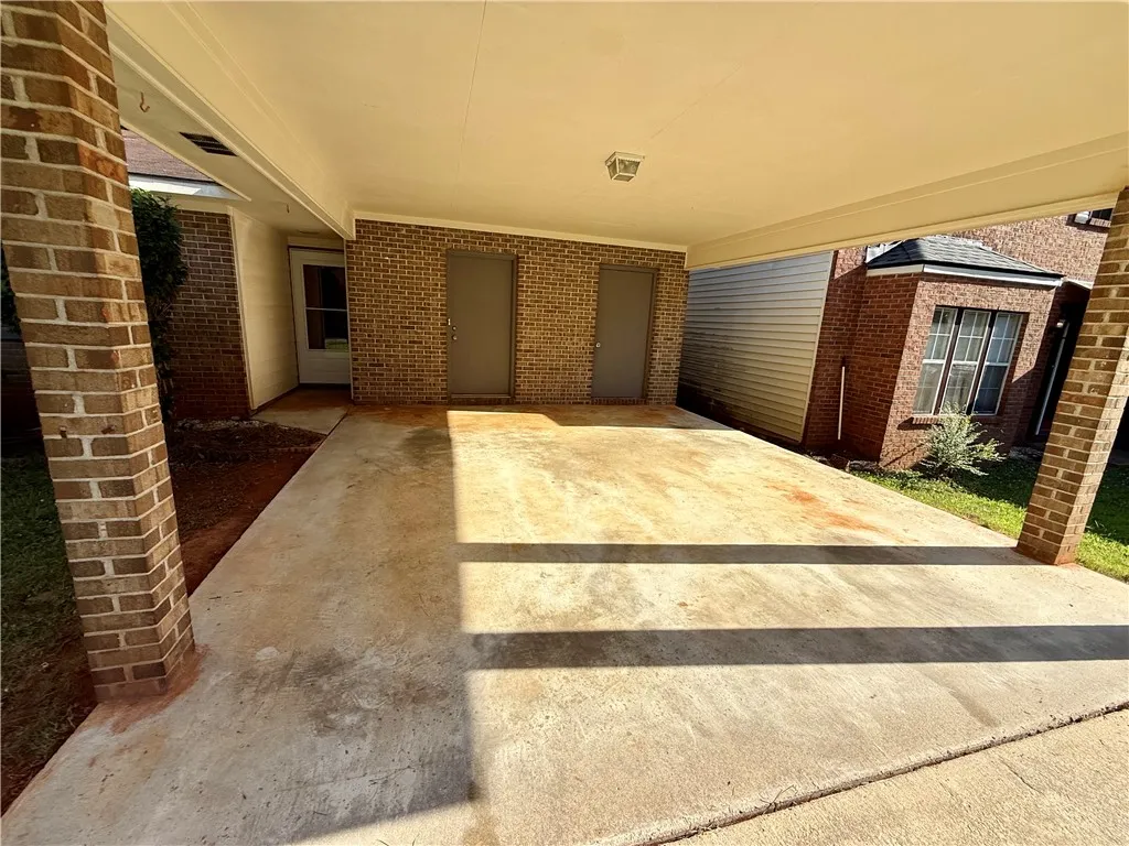 A spacious carport offers convenient, covered parking with direct access to the brick-sided dwelling.