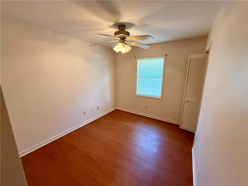 Hardwood floors and a well-lit window create a comfortable and inviting atmosphere in this room.