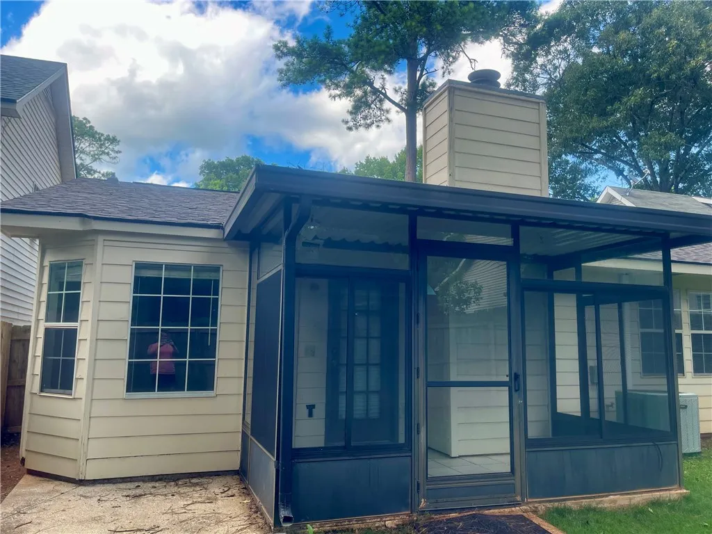 A screened porch offers outdoor living space on the side of this residence.