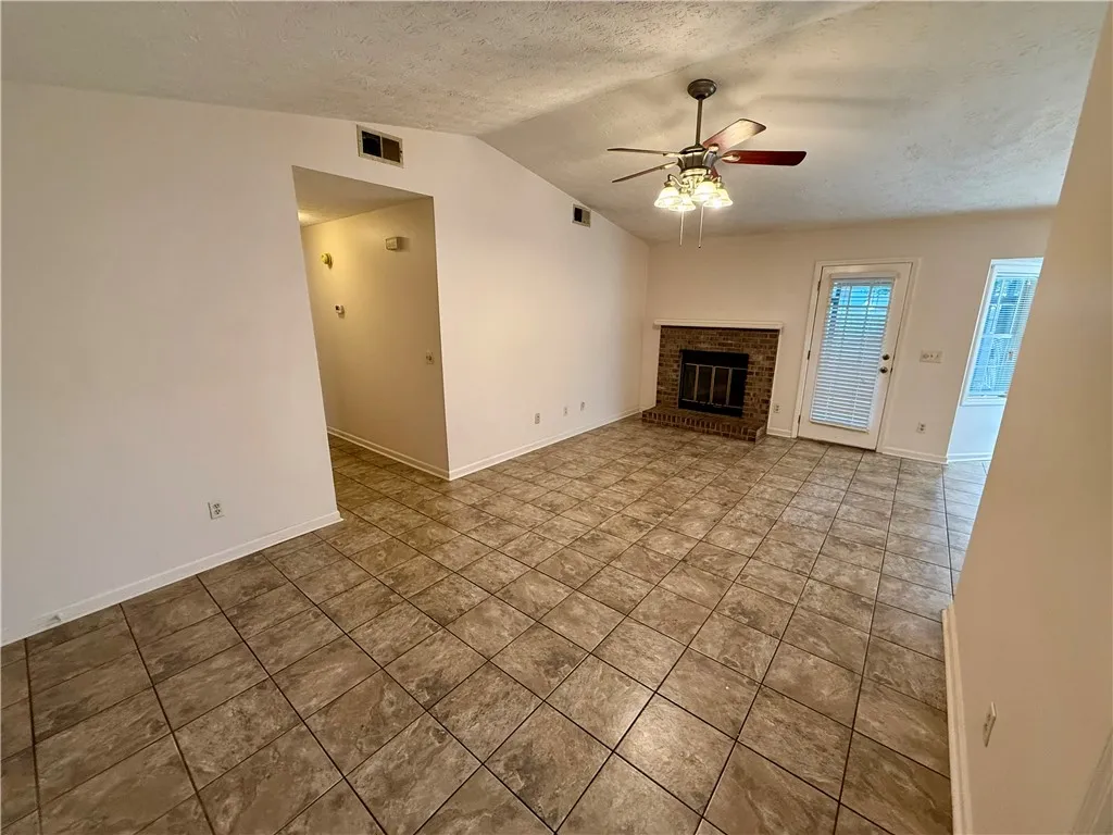 A cozy living area provides a classic brick fireplace and durable tile flooring.