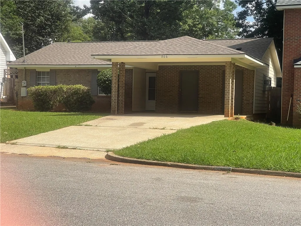 A classic brick exterior with a welcoming carport offers charming curb appeal.