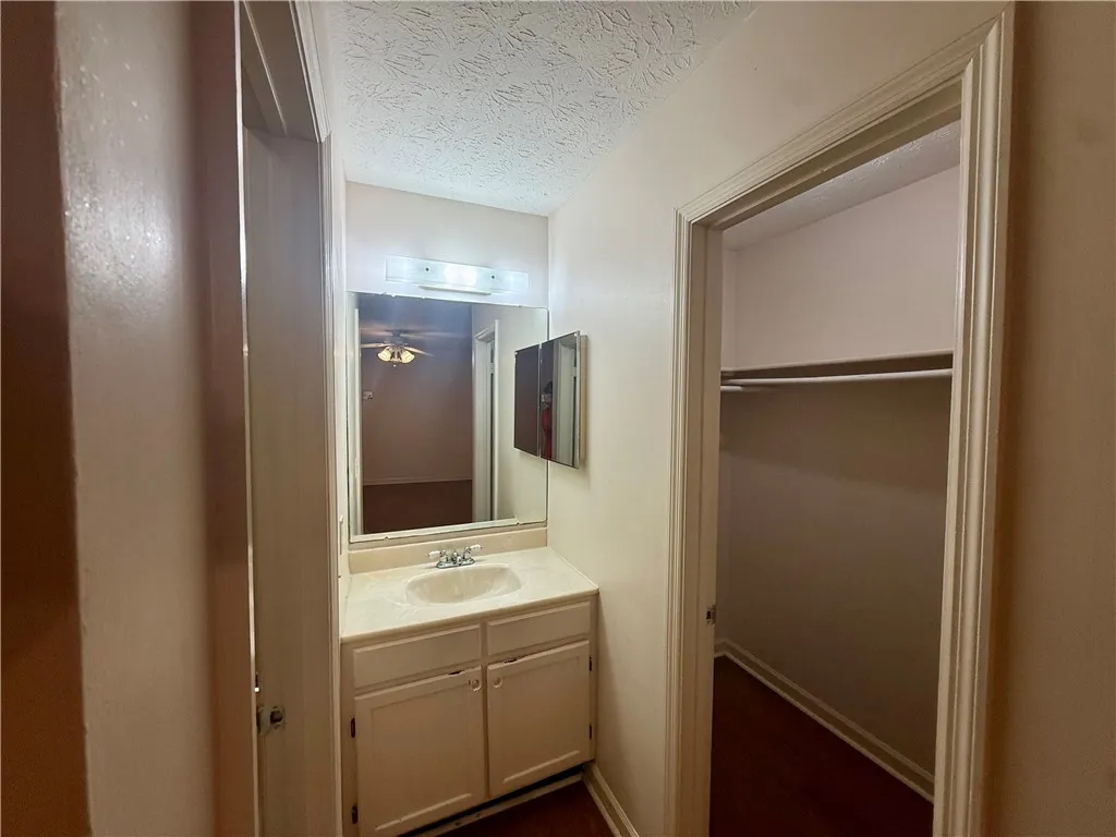 A well-appointed bathroom vanity with ample storage and an adjacent, organized closet space.