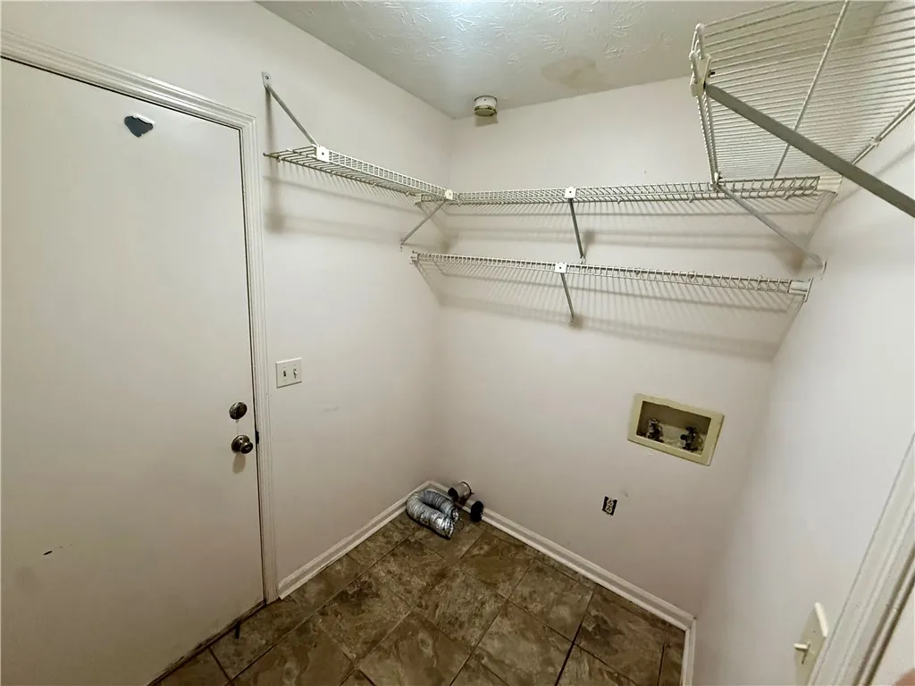 Functional utility room with practical wire shelving and tiled flooring, ready for household tasks.