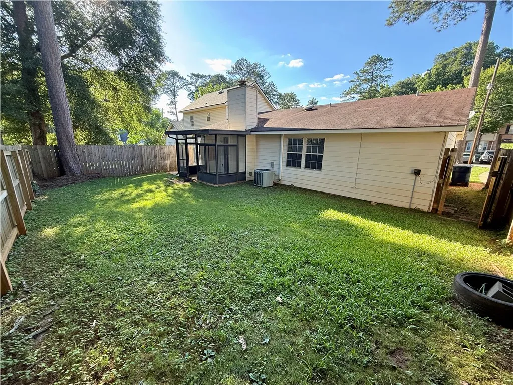 A generous backyard offers a private outdoor haven, bordered by a classic wooden fence.