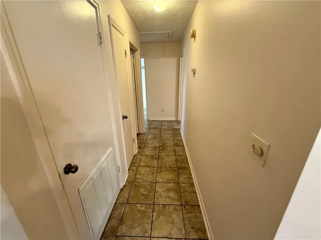A well-lit corridor boasts durable tile flooring, guiding residents through this practical living space.
