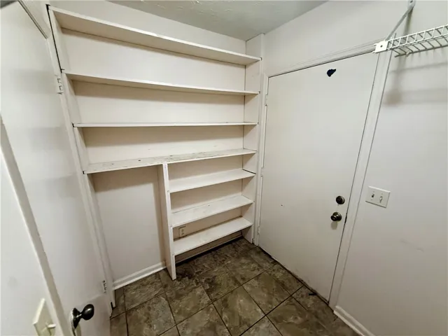 Functional built-in shelving provides ample storage in this versatile utility space.
