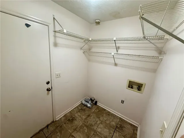 Functional utility room with practical wire shelving and tiled flooring, ready for household tasks.