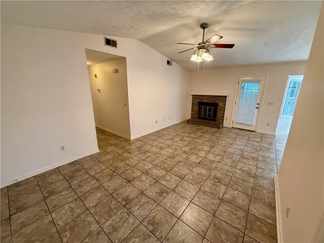 A cozy living area provides a classic brick fireplace and durable tile flooring.