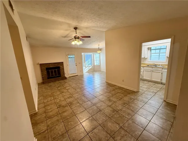 A cozy living space features a classic brick fireplace and durable tile flooring throughout.