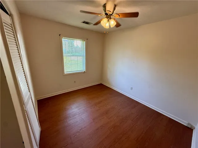 Hardwood-style flooring and a window with blinds define this inviting room.