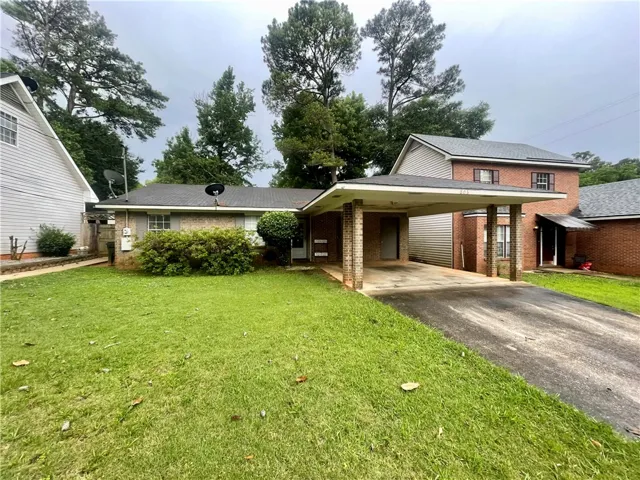 A well-maintained lawn welcomes you to this home featuring a practical carport and durable brick accents.