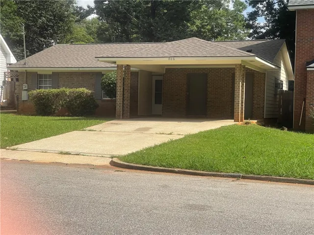 A classic brick exterior with a welcoming carport offers charming curb appeal.