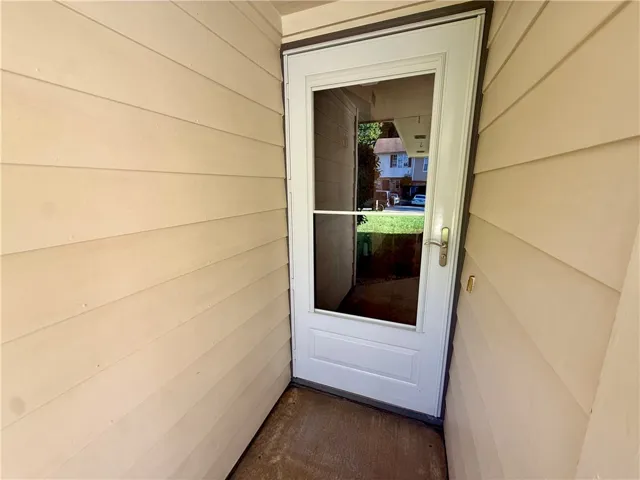 A classic storm door offers a glimpse of the neighborhood beyond, enhancing this welcoming entrance.
