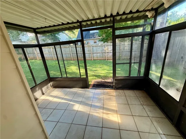 Sun-drenched enclosed patio offers a seamless transition to the private yard.