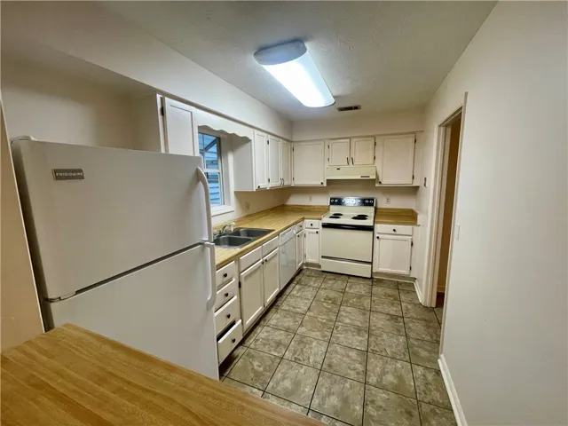 Functional kitchen with ample cabinetry and easy-care tile flooring.