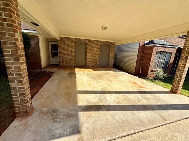A spacious carport offers convenient, covered parking with direct access to the brick-sided dwelling.
