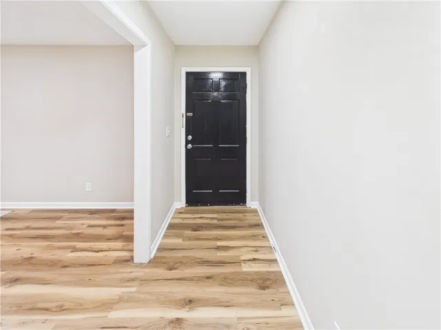 A welcoming entry featuring warm wood flooring and clean, light walls.