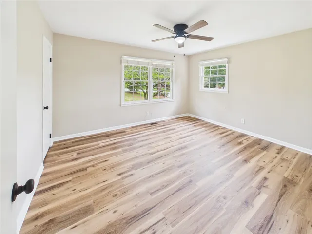 Ample natural light illuminates this tranquil bedroom with stylish hardwood flooring.