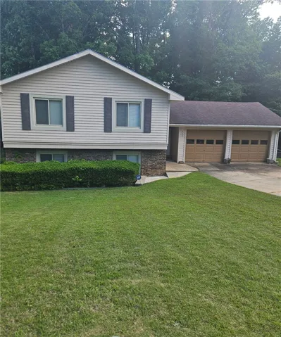 A well-maintained lawn welcomes you to this classic suburban home with an attached garage.