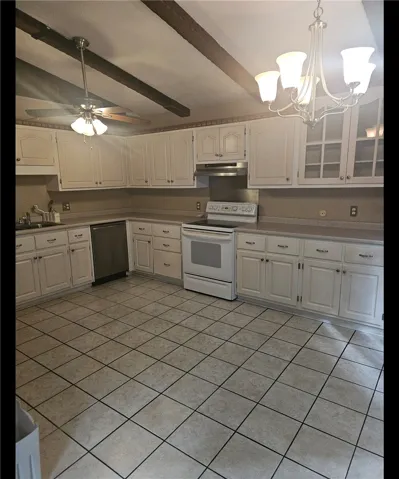A classic kitchen with exposed ceiling beams and a practical layout awaits culinary creations.