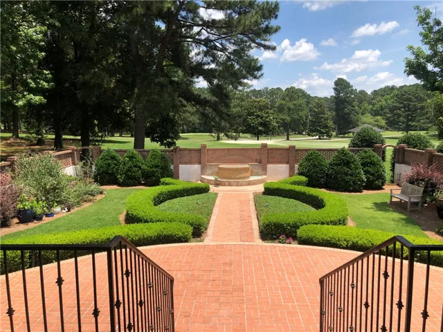 A captivating brick patio and manicured gardens overlook a serene golf course.