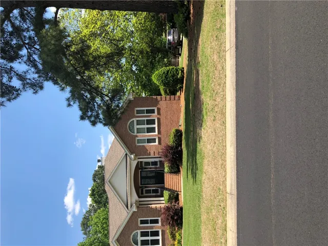 A classic brick exterior, framed by mature trees, provides inviting curb appeal.