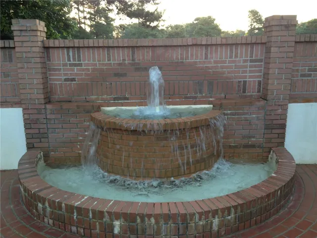 A tiered brick water feature creates a soothing focal point in the outdoor space.