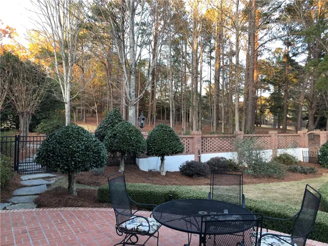 Enjoy tranquil moments on the brick patio, enveloped by manicured shrubs and a picturesque brick privacy wall.