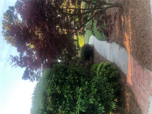 A welcoming brick pathway guides visitors through meticulously maintained landscaping to the front entry.