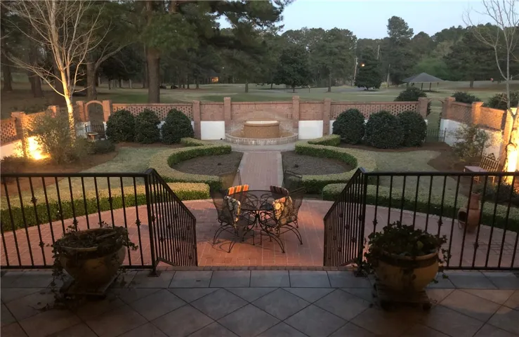 A private brick patio and garden, perfect for outdoor entertaining, overlooks a tranquil green landscape.