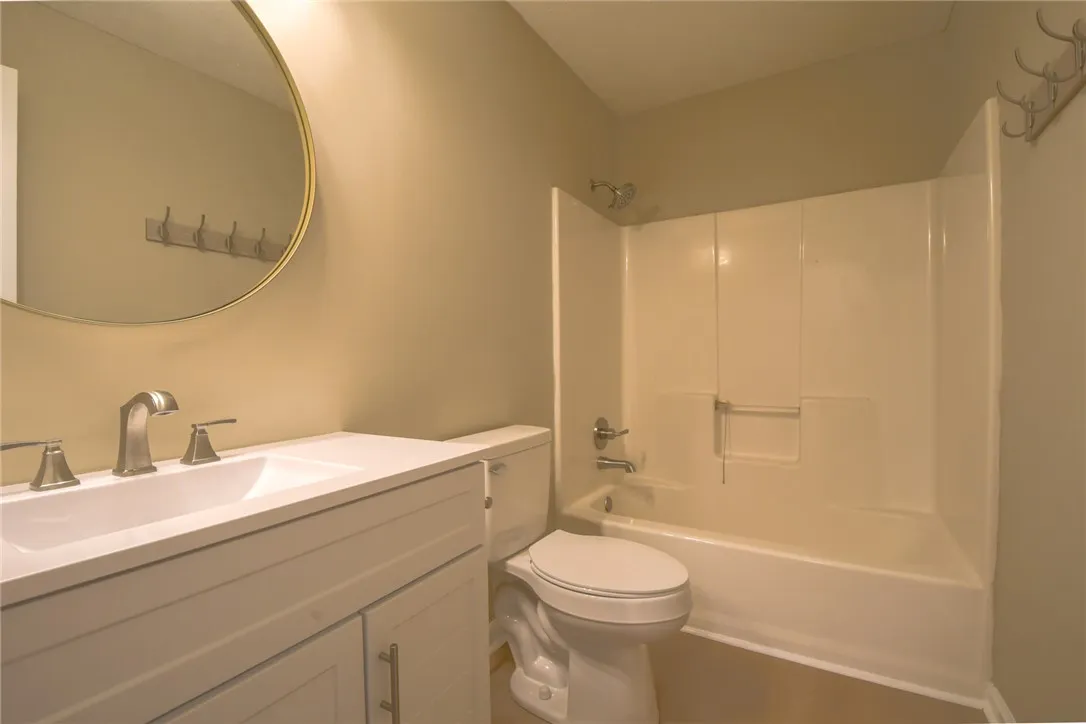 A well-appointed bathroom features a crisp white vanity and a practical shower-tub combination.