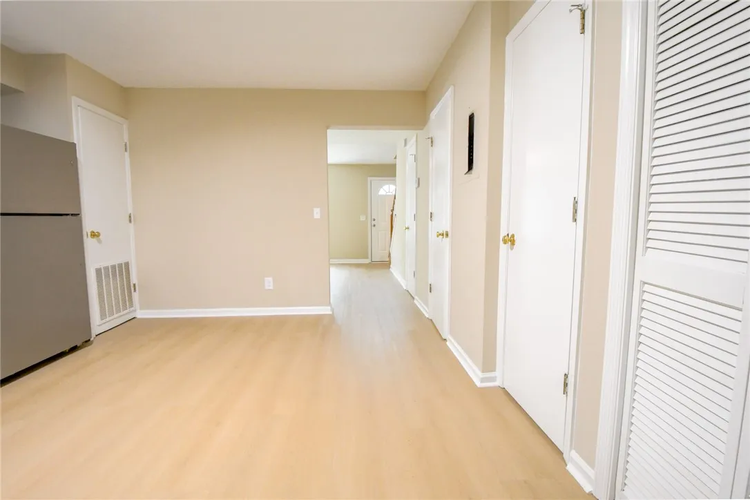 Blonde hardwood-style flooring extends through this airy living space and into the welcoming entrance foyer.