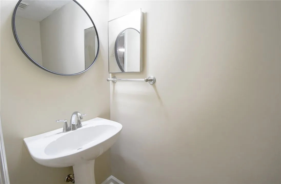 A pristine pedestal sink paired with modern mirrors creates a refreshing powder room experience.