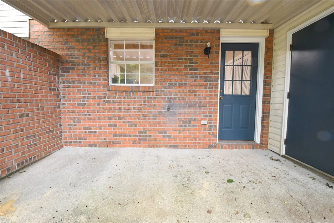 A sheltered brick facade with a secure entry door offers a practical outdoor area.