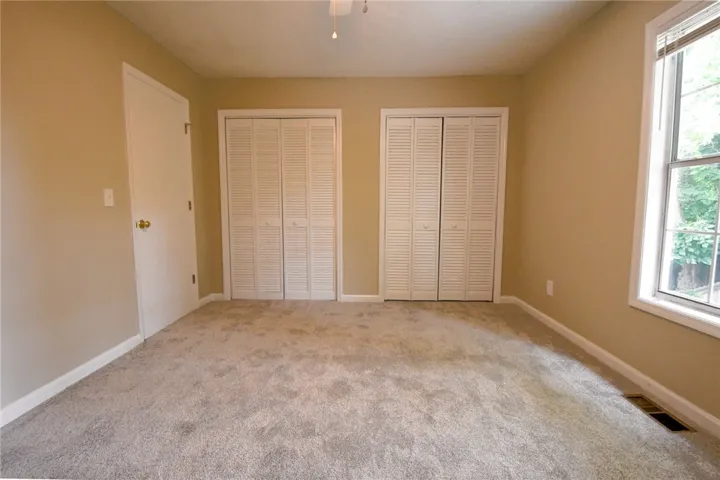 A well-proportioned bedroom offers dual closet storage and soft carpeting.