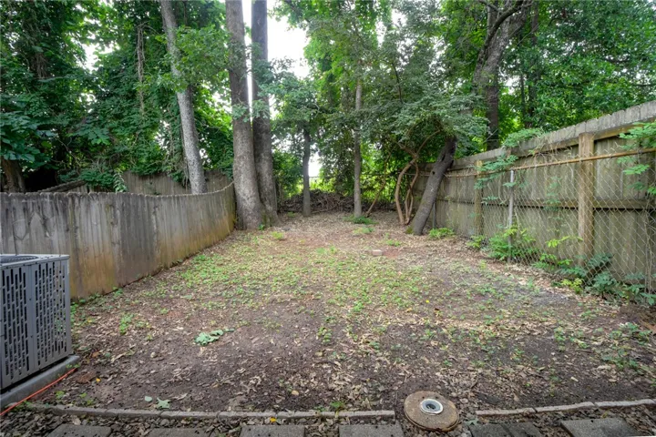 A tranquil backyard, enclosed by fencing, offers a secluded outdoor retreat.