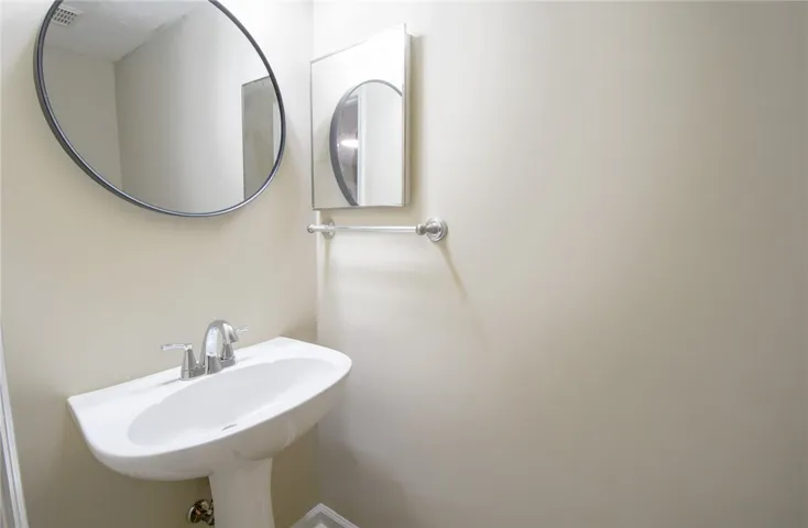 A pristine pedestal sink paired with modern mirrors creates a refreshing powder room experience.