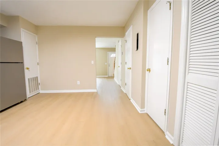 Blonde hardwood-style flooring extends through this airy living space and into the welcoming entrance foyer.