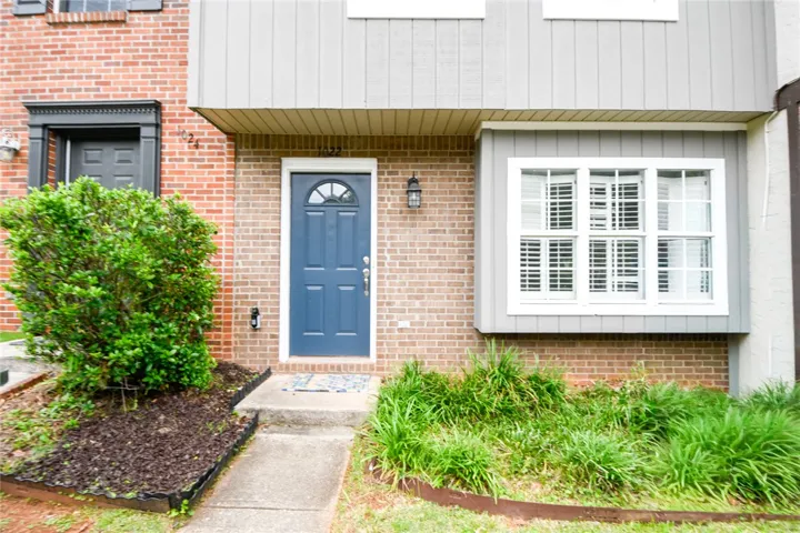 A classic brick exterior with a distinctive blue door offers welcoming curb appeal.