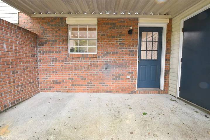 A sheltered brick facade with a secure entry door offers a practical outdoor area.